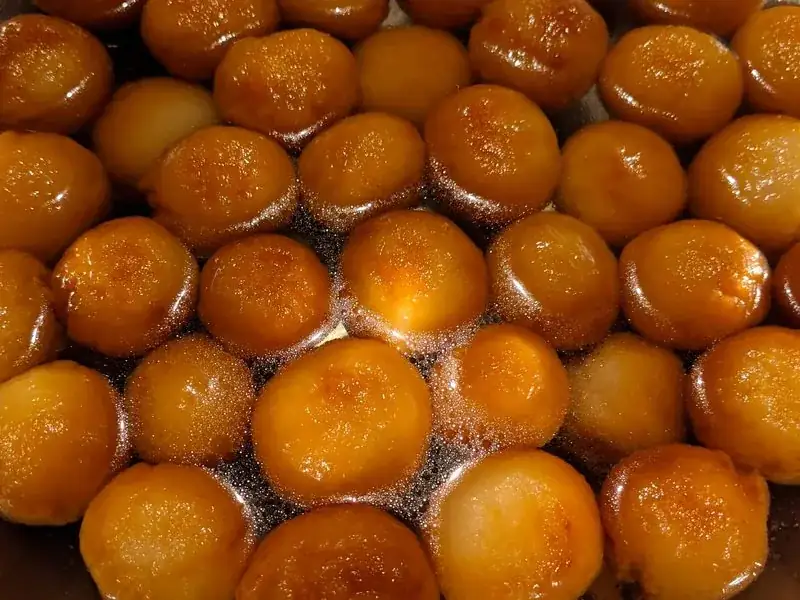 Golden gulab jamun glistening in syrup